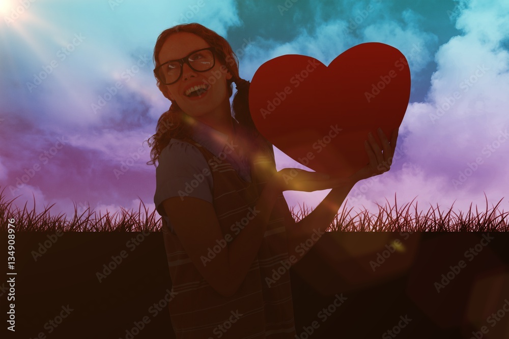 Composite image of geeky hipster woman holding heart card