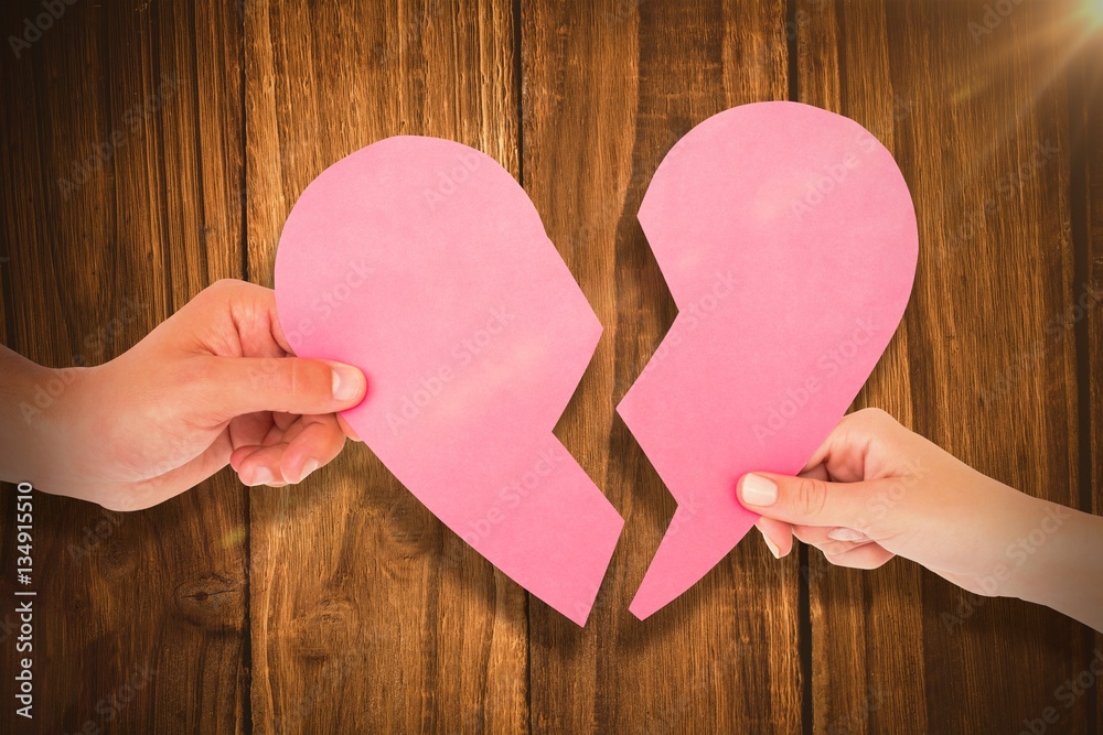 Composite image of couple holding two halves of broken heart