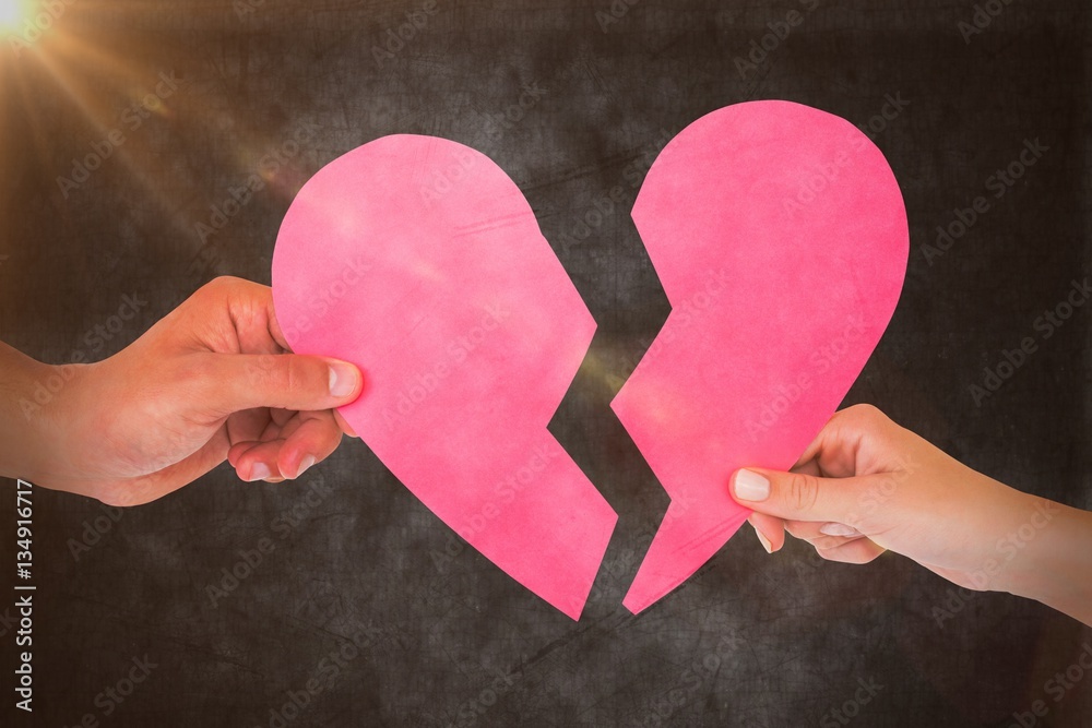 Composite image of couple holding two halves of broken heart