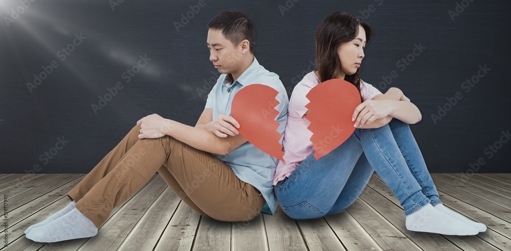 Composite image of sad couple holding broken heart pieces