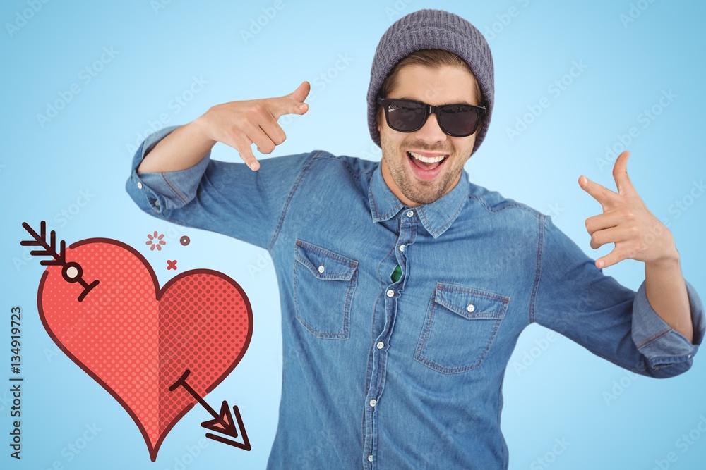 Composite image of happy hipster showing rock and roll hand sign