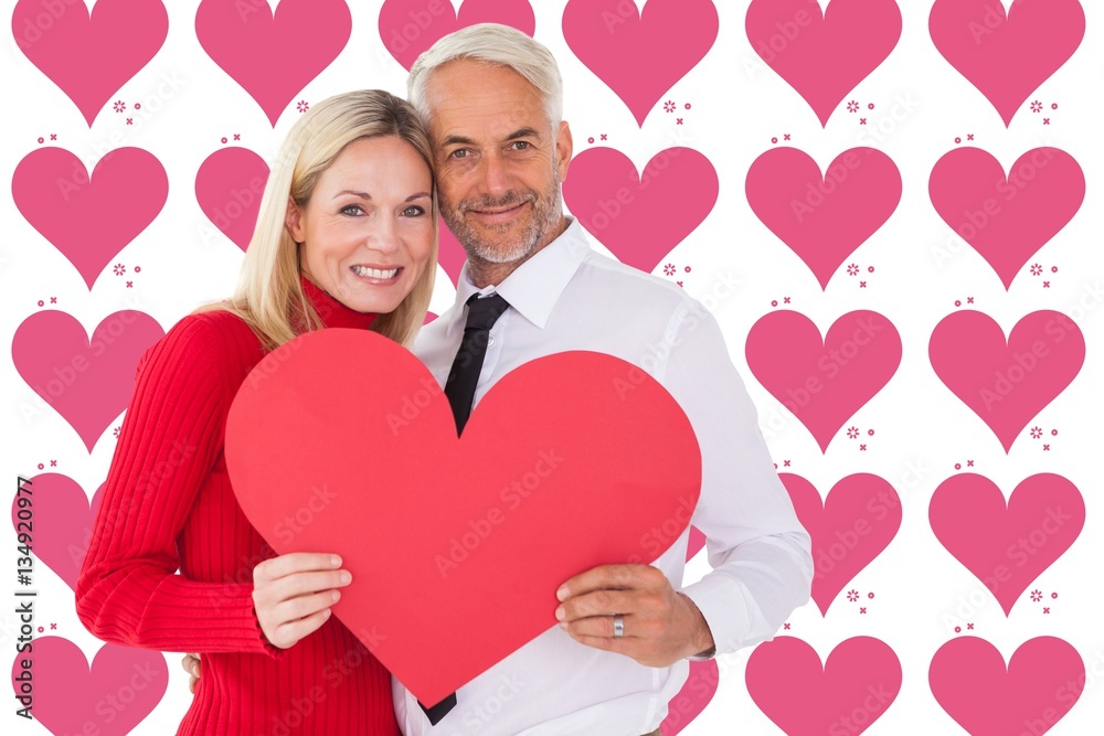 Composite image of handsome man getting a heart card form wife