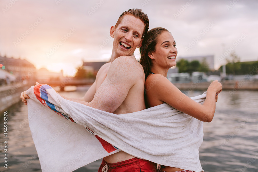 Couple wiping their body after swimming.