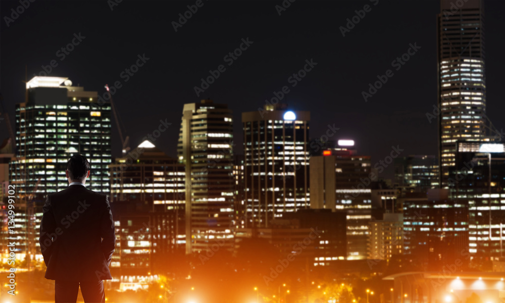 Businessman viewing night glowing city