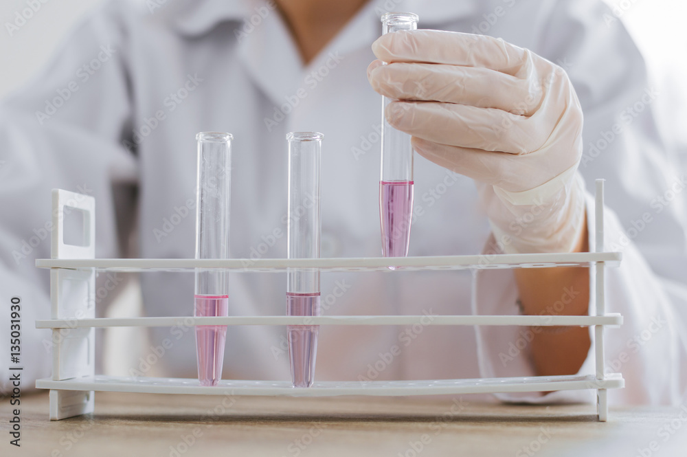 Scientist with test tube making research in clinical laboratory