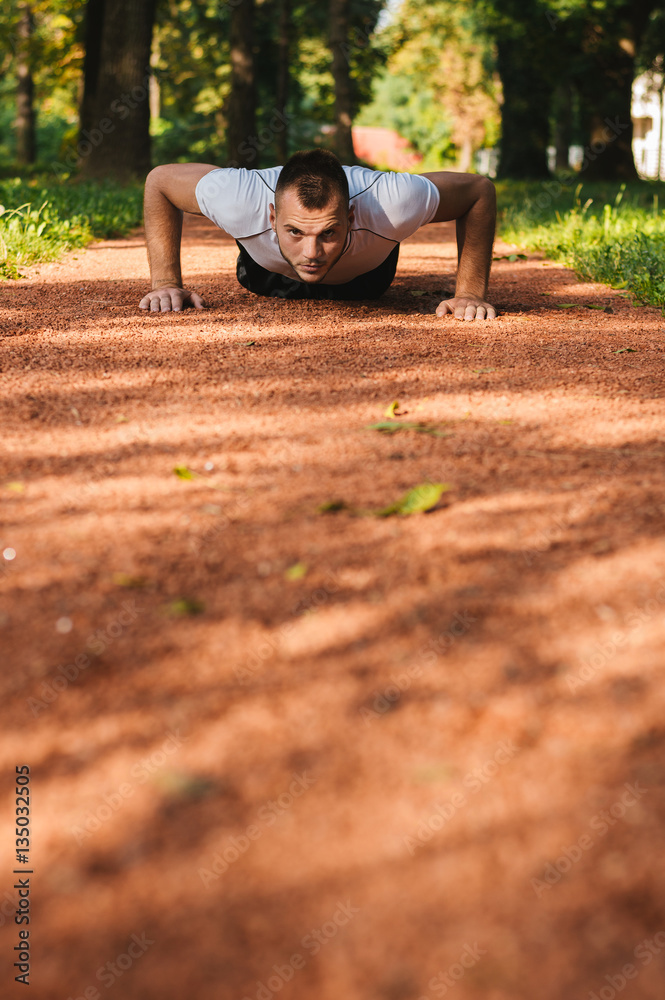 Sport men doing push-ups during outdoor cross training workout i