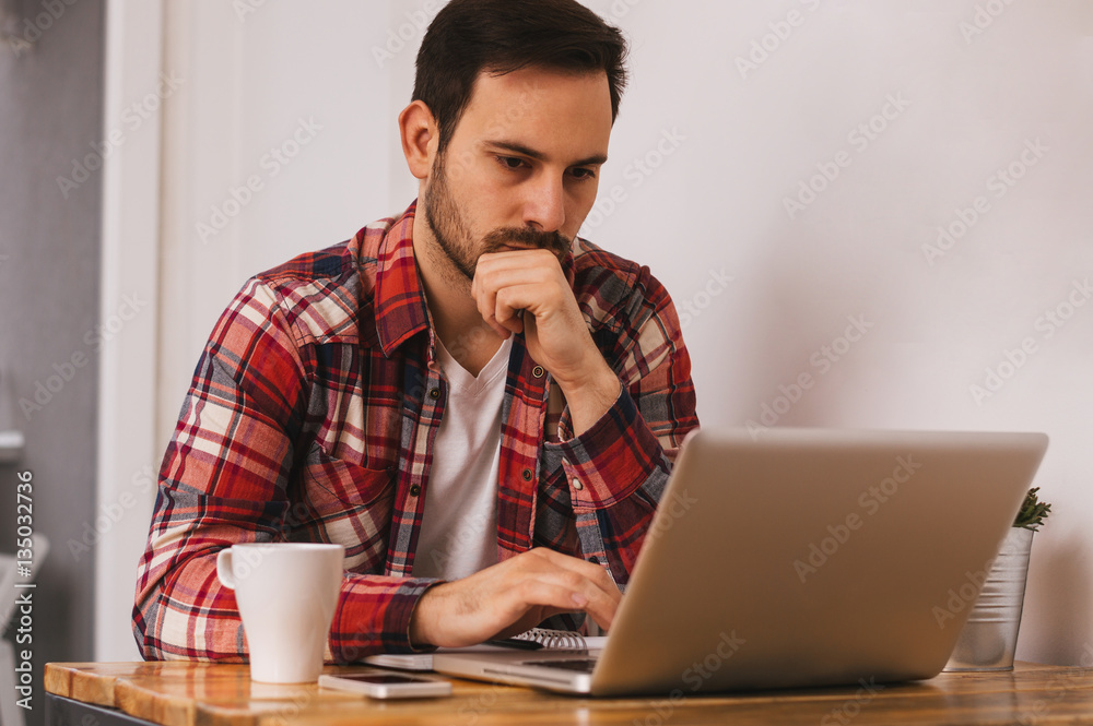 Handsome guy working on project at modern office desk