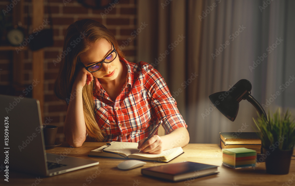 young woman student working on the computer at night