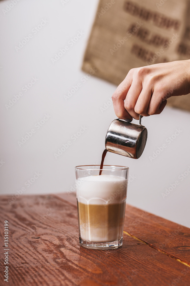 Making late coffee. Putting coffee in milk.