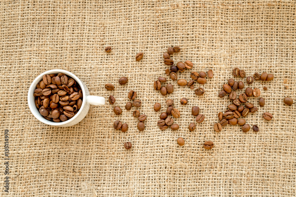 coffee beans, coffe cup on linen cloth background top view