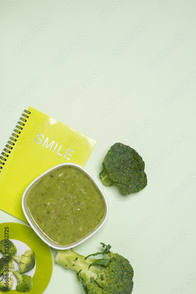 Tasty broccoli soup on a green background