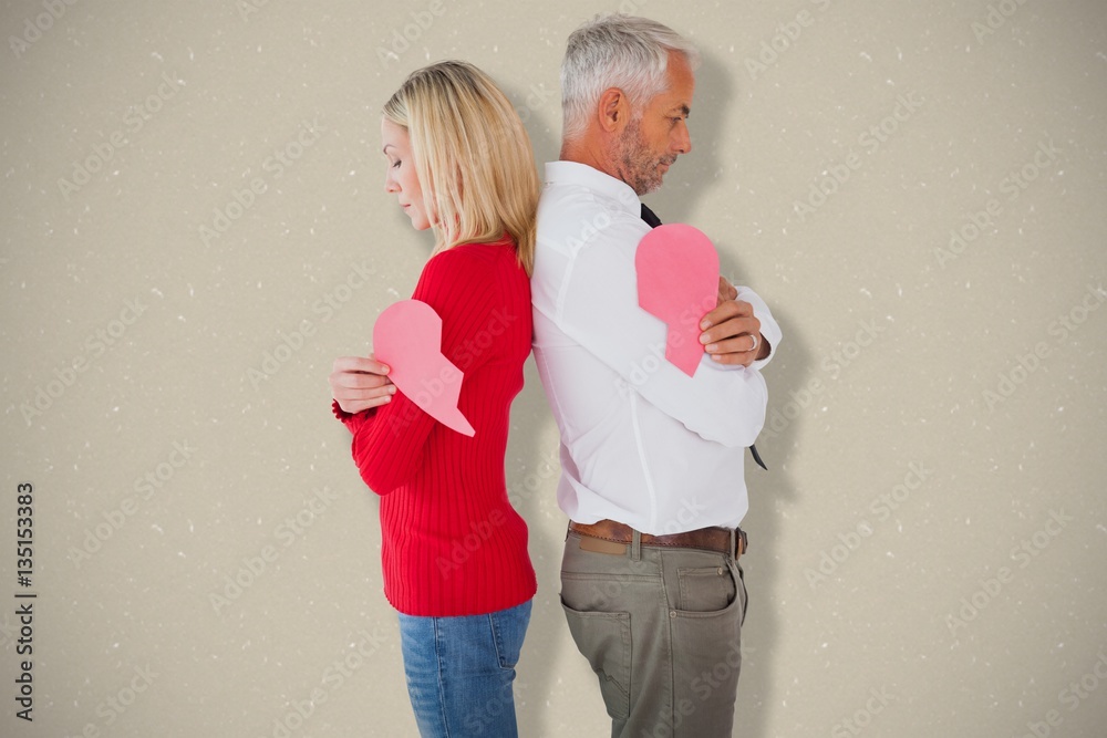 Composite image of couple holding two halves of broken heart