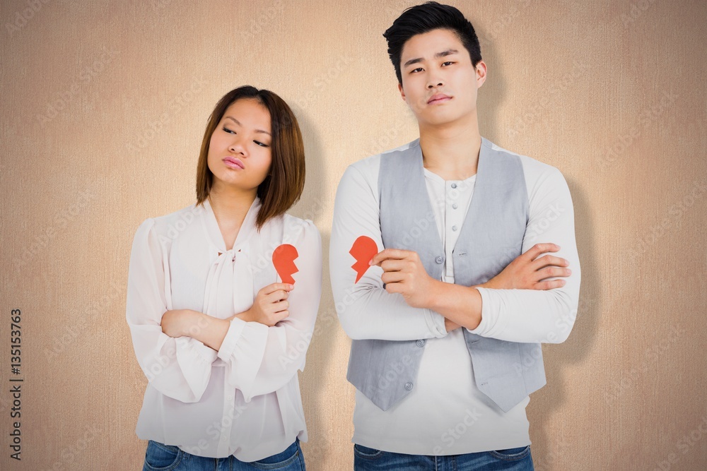 Composite image of young couple holding broken heart