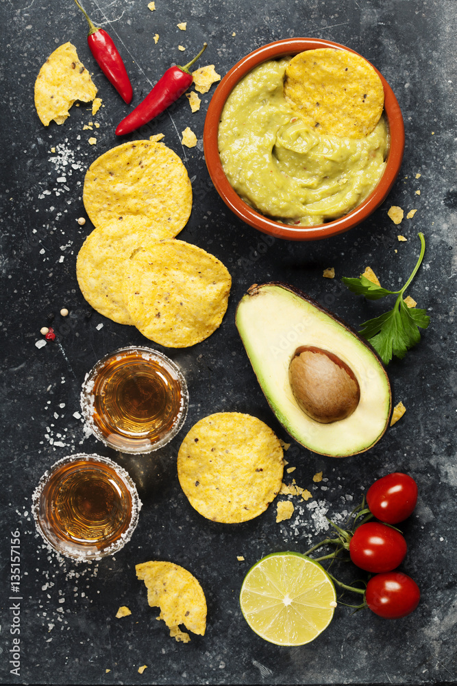 Bowl of mexican nachos chips with homemade fresh guacamole sauce