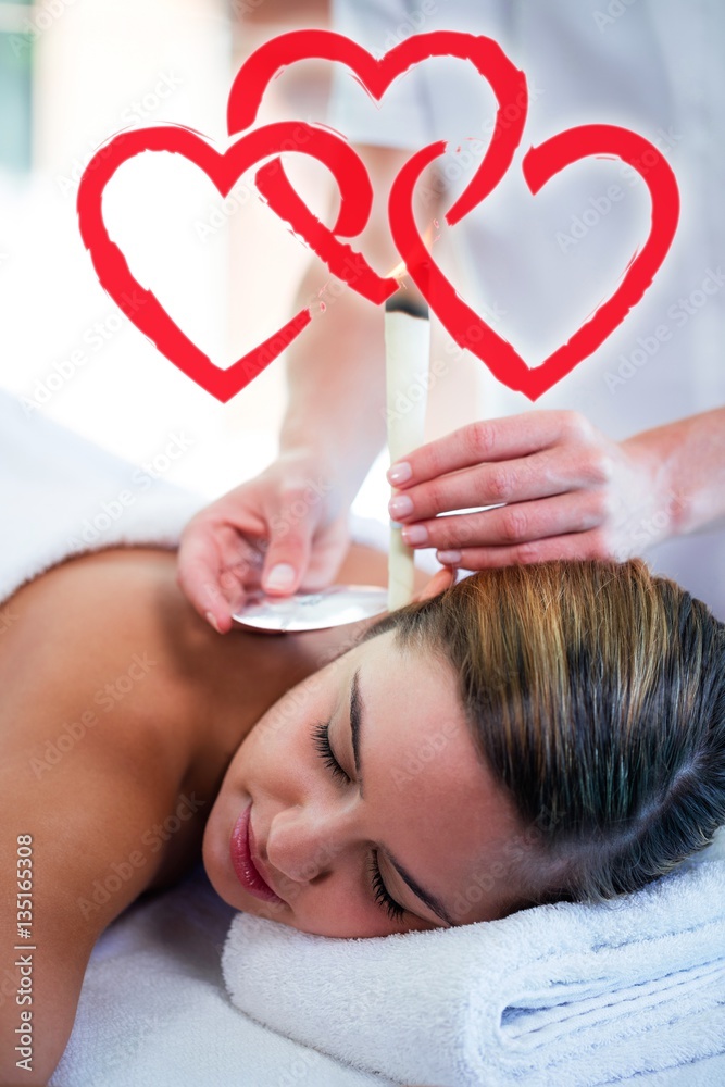 Composite image of woman receiving ear candle treatment