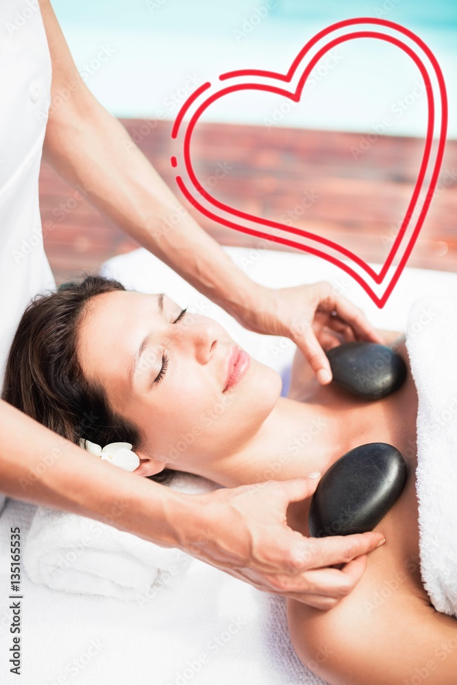 Composite image of woman receiving a massage with love heart 