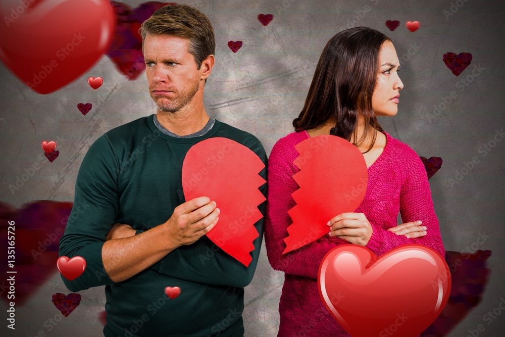 Composite image of serious couple holding cracked heart shape 3d