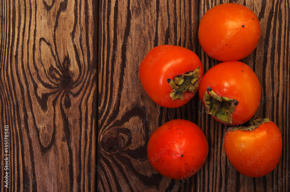  persimmon fruit on wooden background