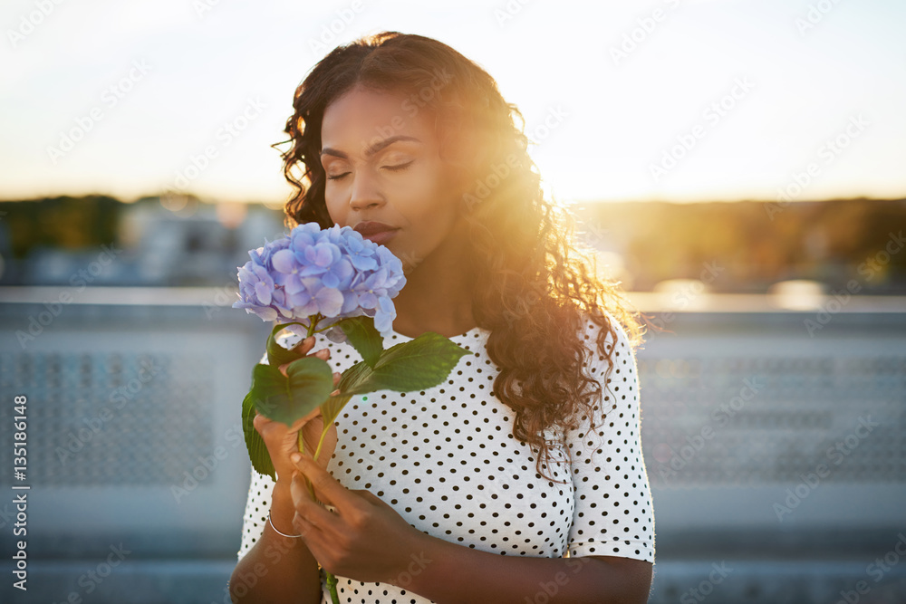 Black woman enjoying a pretty flower