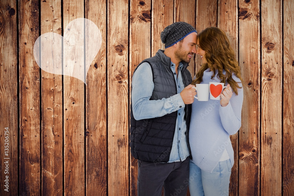 Composite image of happy young couple holding coffee mug