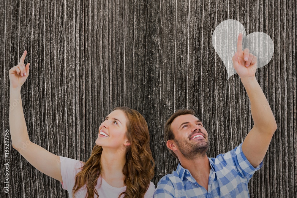 Composite image of young couple looking up and smiling