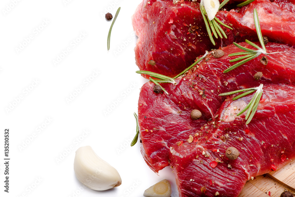 Pieces of meat with garlic and rosemary isolated on white background. Raw beef. Top view.