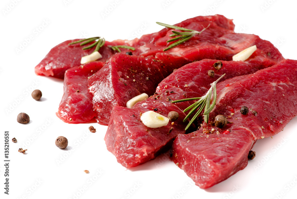 Pieces of meat with garlic and rosemary isolated on white background. Raw beef.