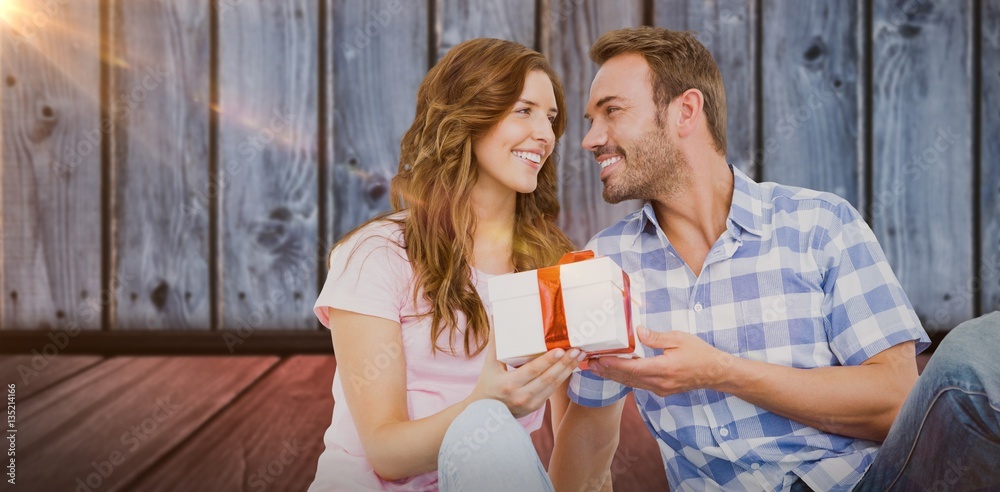 Composite image of man giving gift to woman