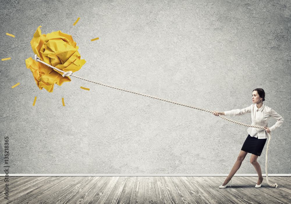 Businesswoman pulling paper ball with rope and making it raise up