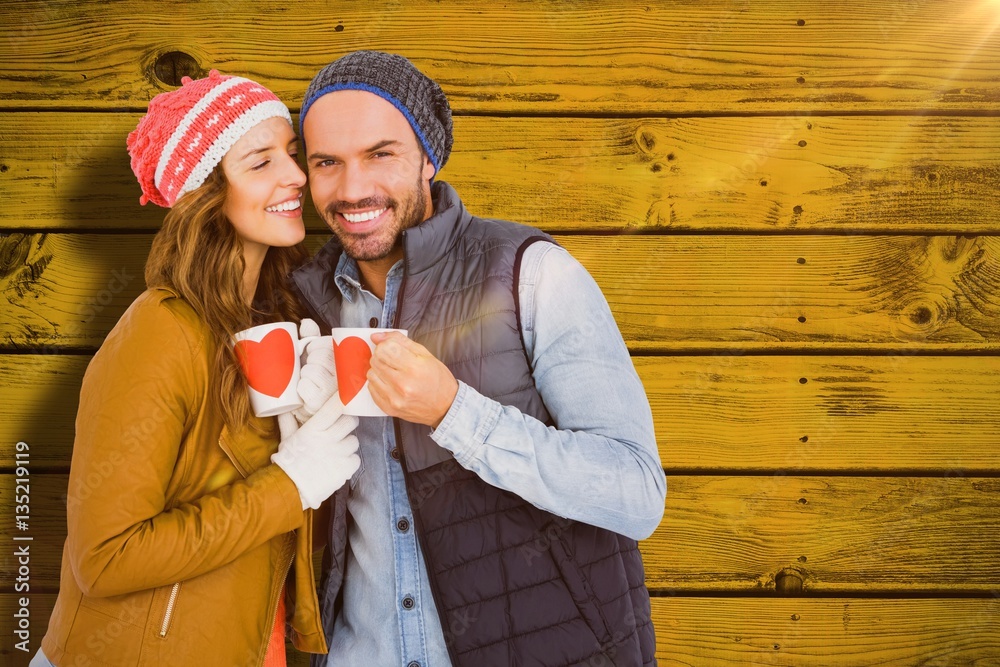 Composite image of happy young couple holding coffee mug