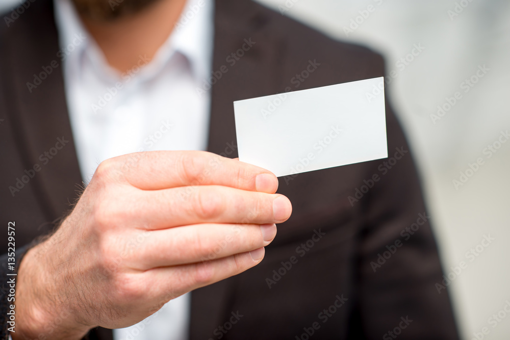 Man in the suit showing business card. Close-up view on the empty card to copy paste