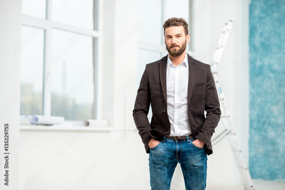 Portrait of handsome architect or designer standing in the white room