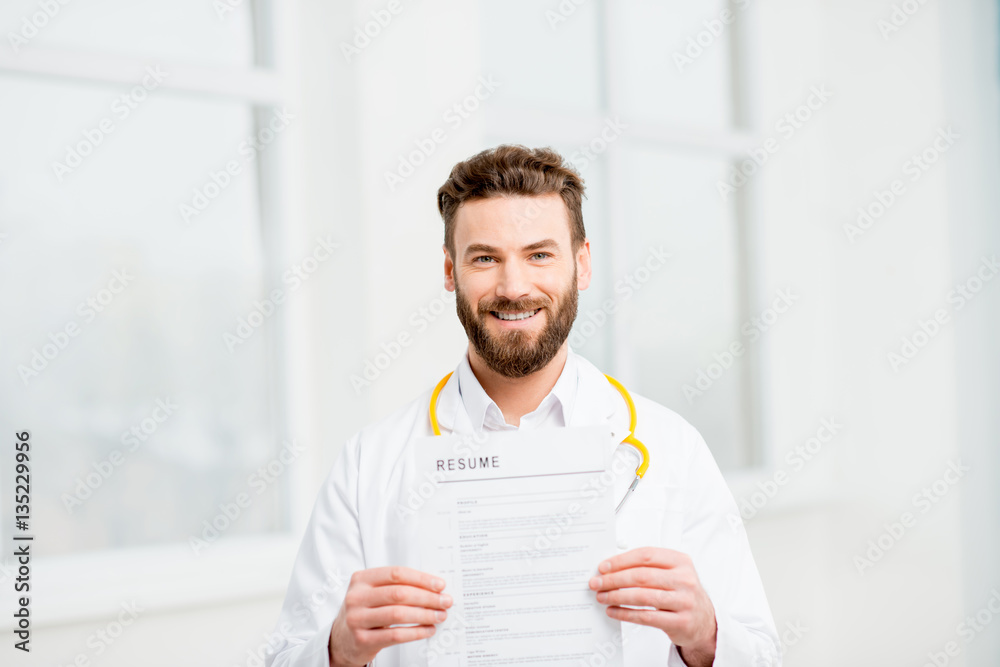 Doctor in uniform holding resume for job hiring in the white interior