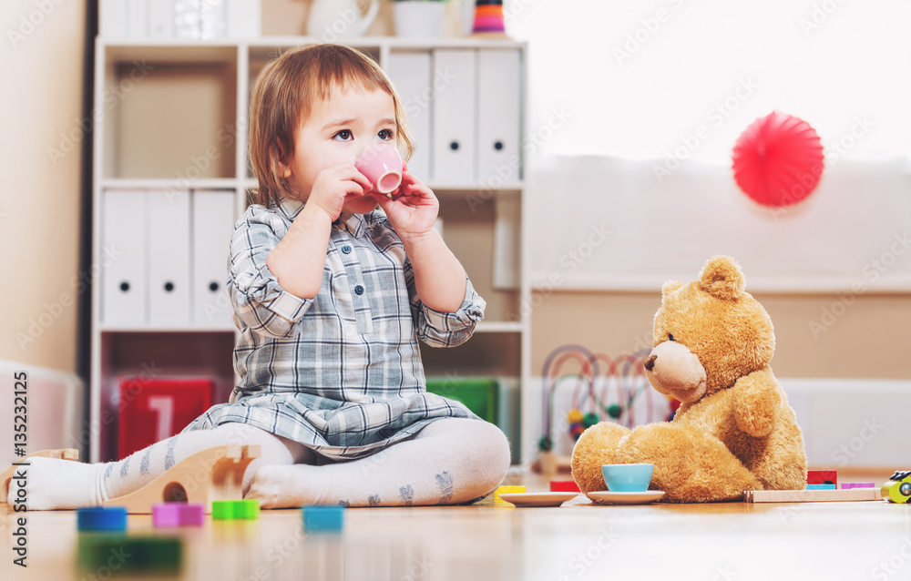 Happy toddler girl playing with toys