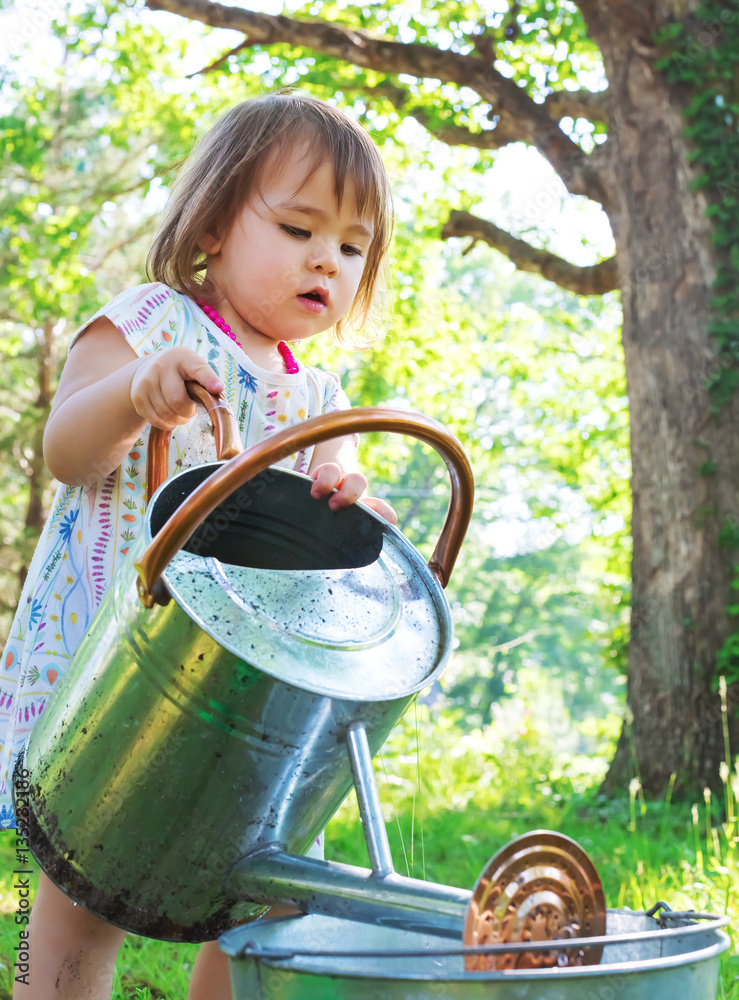 Happy toddler girl playing outside on a summer day