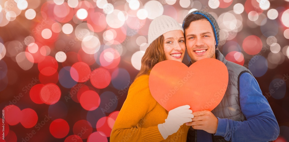 Composite image of portarit of happy couple holding paper heart