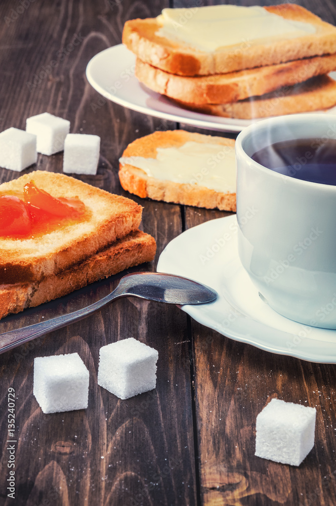 Healthy breakfast with cup of tea, bread, butter and jam