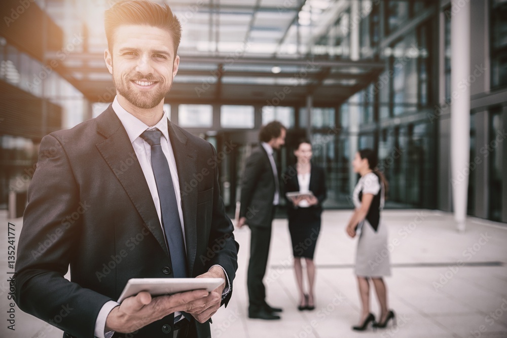 Happy businessman holding digital tablet