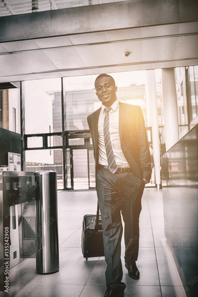 Happy businessman walking with suitcase