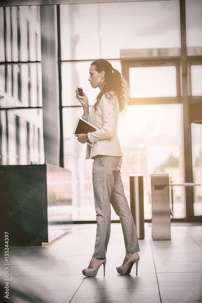 Businesswoman holding digital tablet and mobile phone