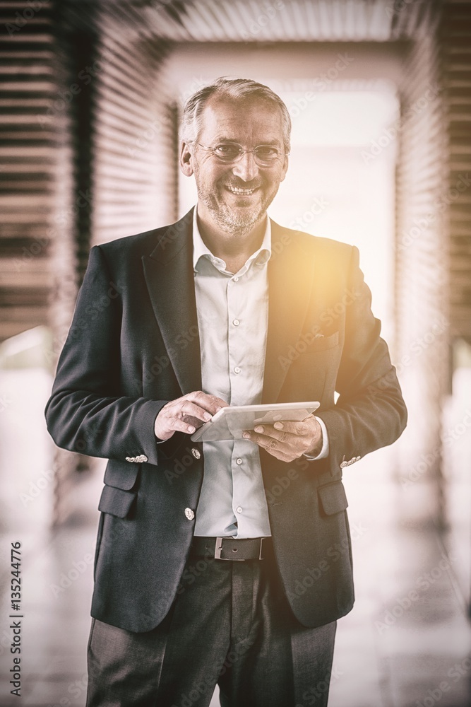 Cheerful businessman holding digital tablet