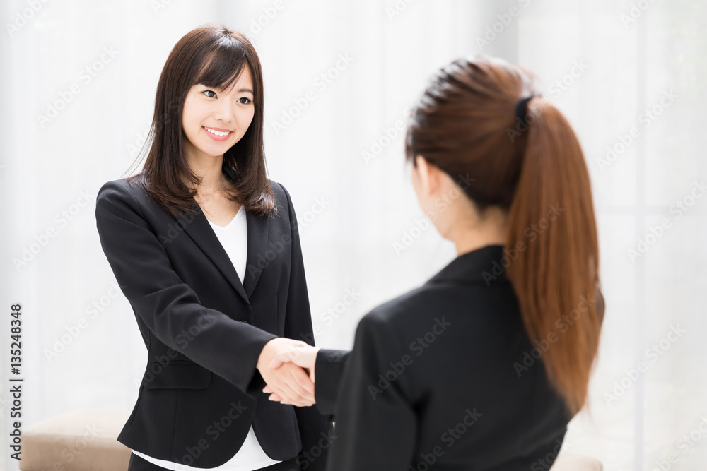 asian businesswomen shaking hands