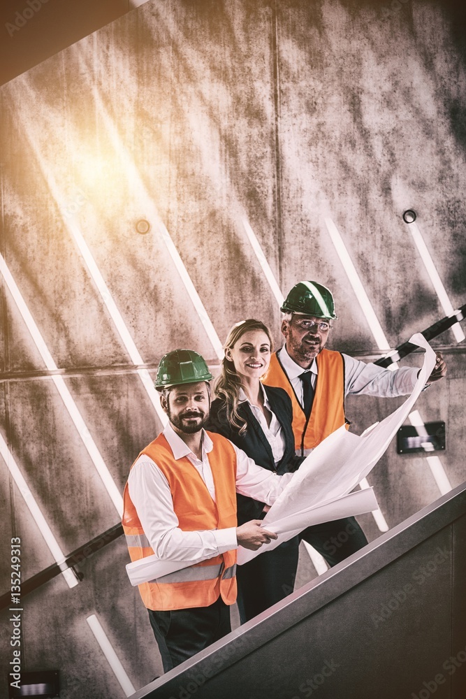 Portrait of businesswoman and architects standing on staircase