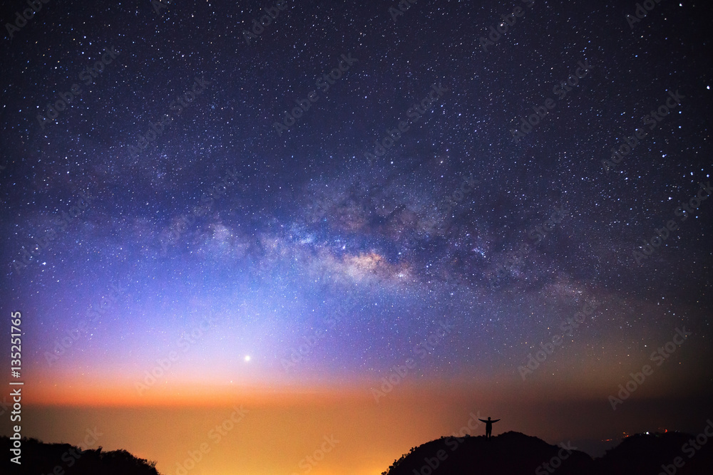 milky way galaxy and silhouette of a standing happy man on Doi L