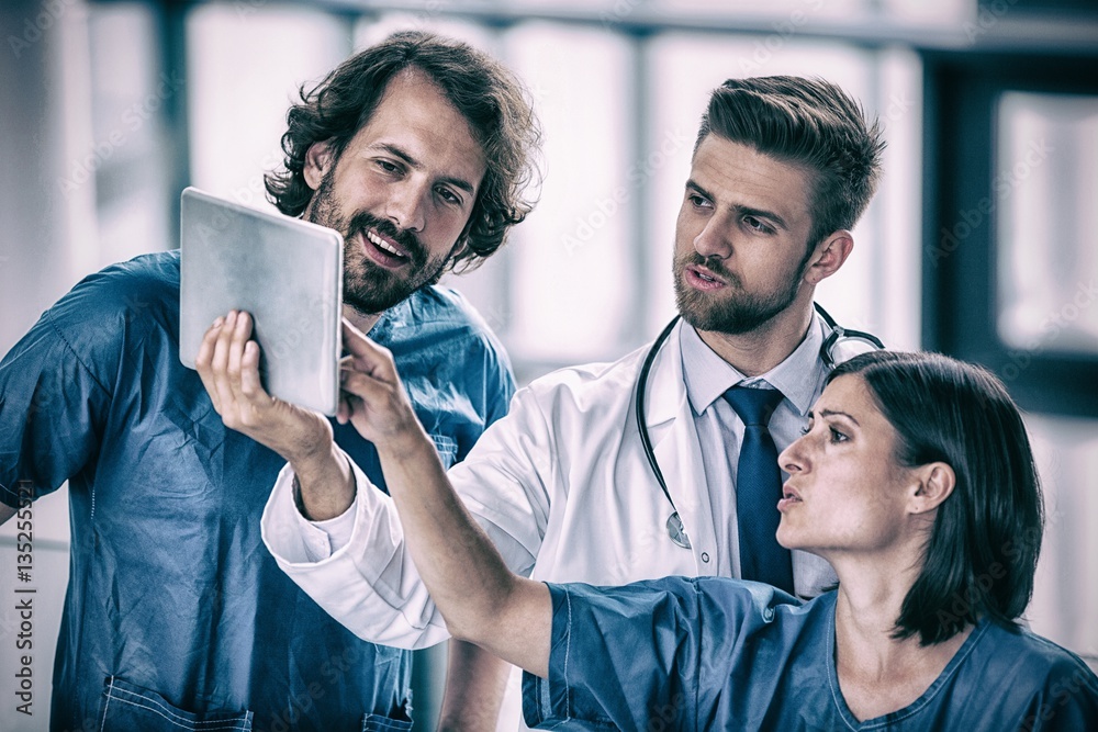 Surgeons and doctor looking at digital tablet