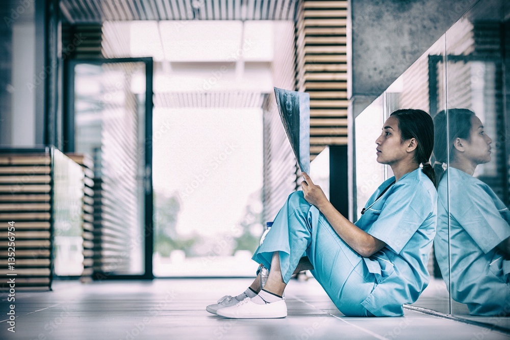 Stressed nurse looking at X-ray report