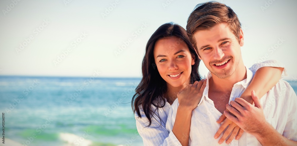 Cheerful couple embracing on the beach 