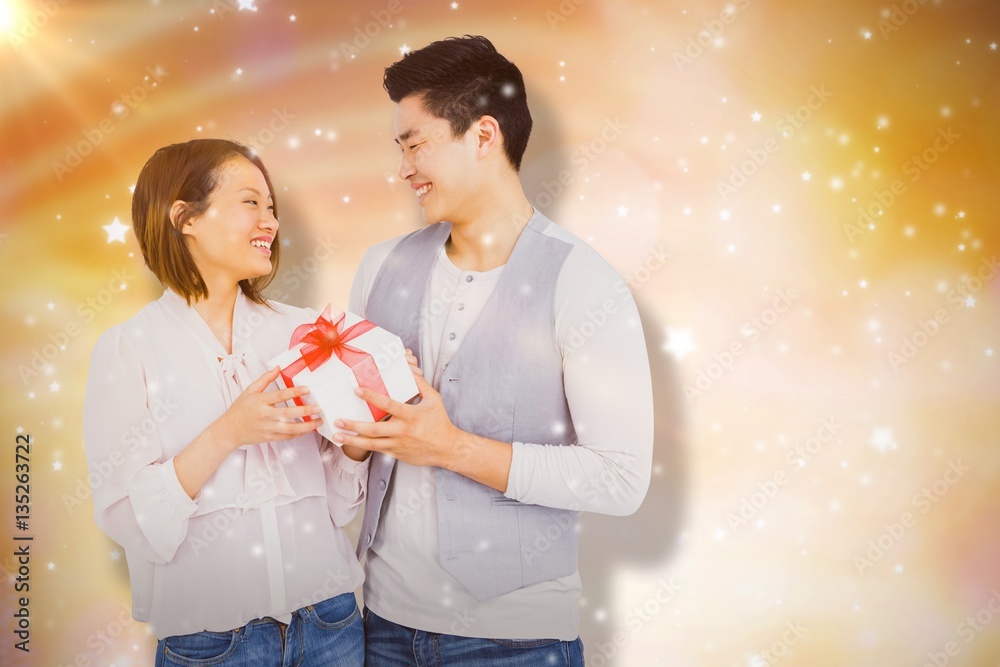 Composite image of young man giving present to woman