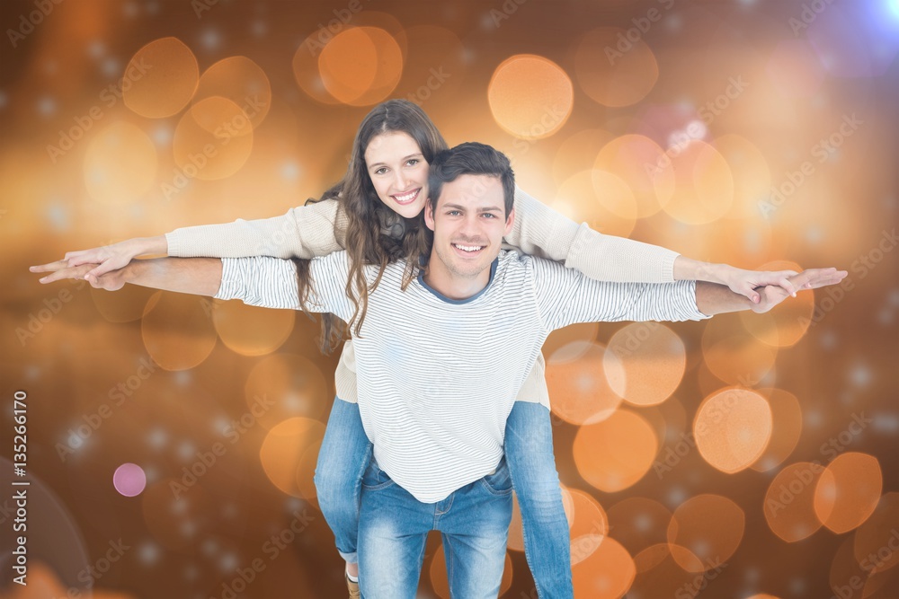 Composite image of portrait of young couple piggybacking