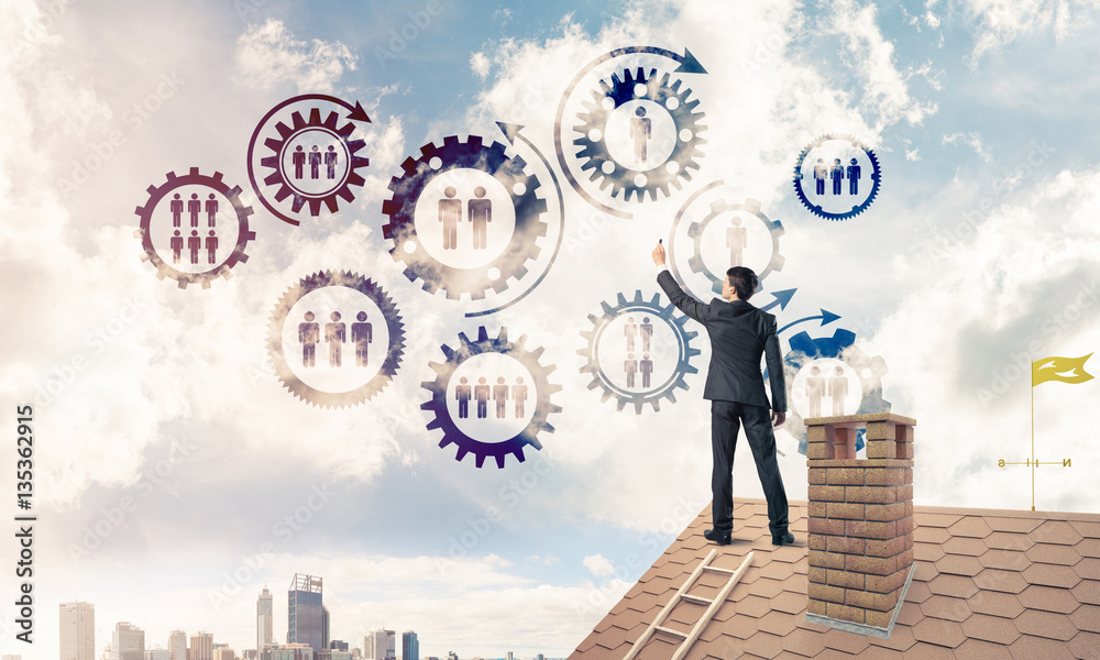 Businessman on house roof presenting teamwork and connection con